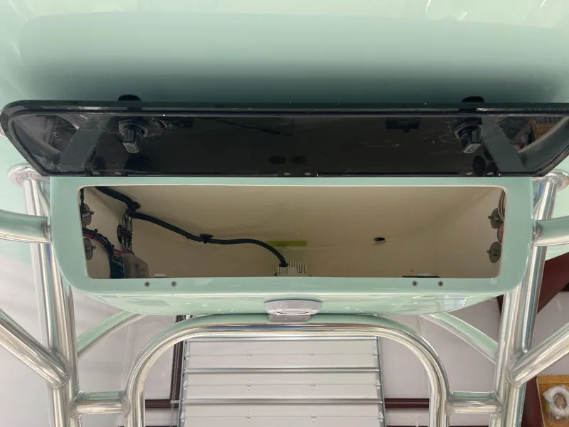 Slide: The Image of 2024 Key West 244CC boat storage compartment with open lid and visible wiring. - 33