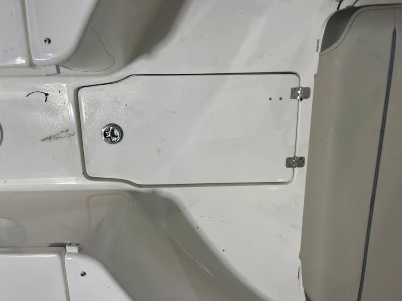 Slide: The Image of 2024 Key West 244CC boat storage compartment with secure latch and hinges. - 40