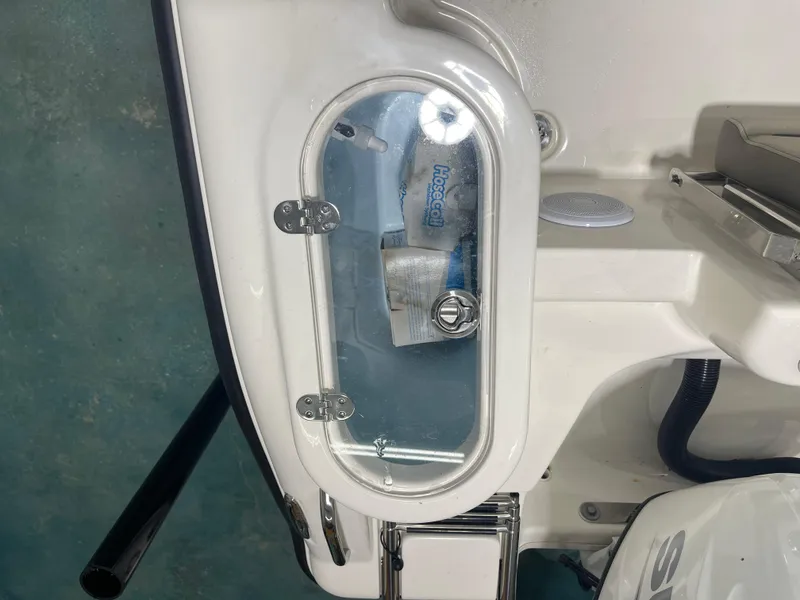 Slide: The Image of 2024 Key West 244CC boat compartment with clear lid and visible contents. - 42