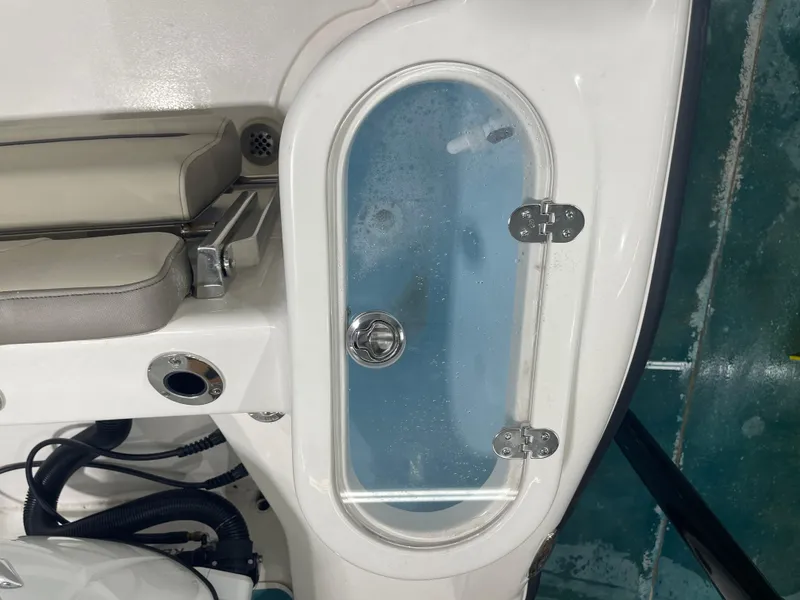 Slide: The Image of 2024 Key West 244CC boat livewell with transparent lid and cushioned seat. - 43