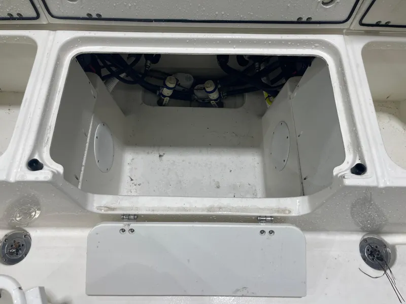 Slide: The Image of 2024 Key West 291FS boat storage compartment with visible wiring and fittings. - 32