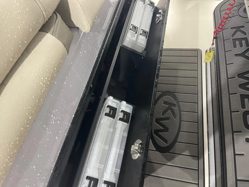 Slide: The Image of 2024 Key West 291FS boat storage compartments with tackle boxes and cushioned seating. - 48