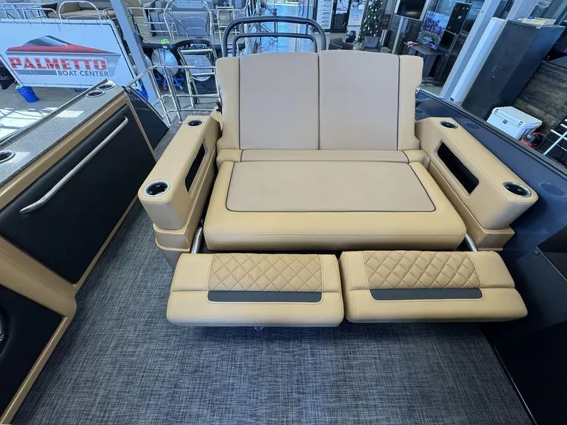 Slide: The Image of 2025 Godfrey AquaPatio 255 DFLW boat interior with beige seating and cup holders. - 16