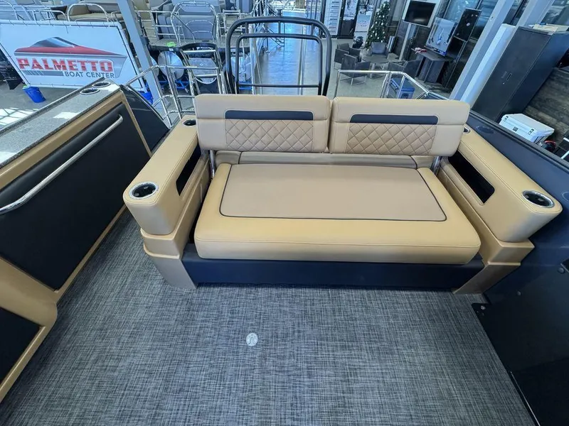 Slide: The Image of 2025 Godfrey AquaPatio 255 DFLW boat interior with tan seating and cup holders. - 17