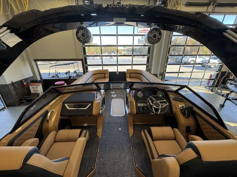 Slide: The Image of Interior of 2025 Godfrey AquaPatio 255 DFLW luxury pontoon boat with modern seating and controls. - 19
