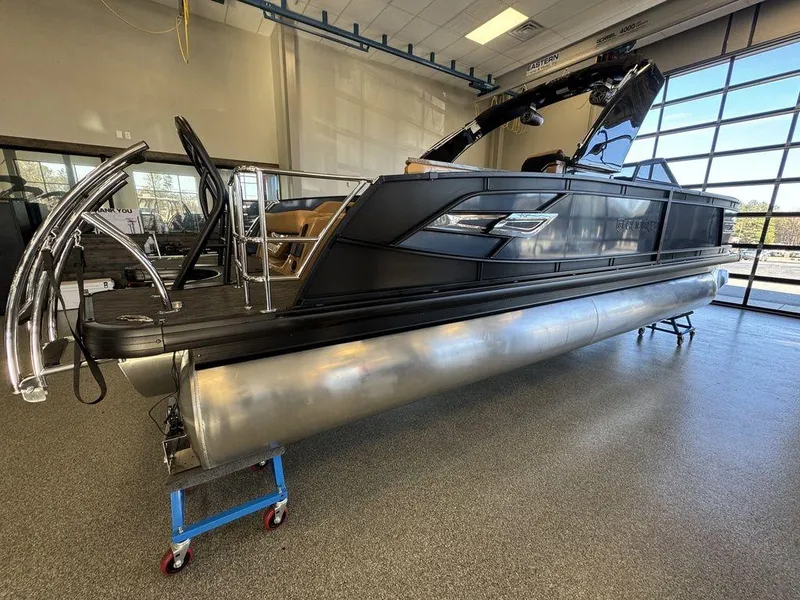 Slide: The Image of 2025 Godfrey AquaPatio 255 DFLW pontoon boat in showroom, sleek black design. - 8
