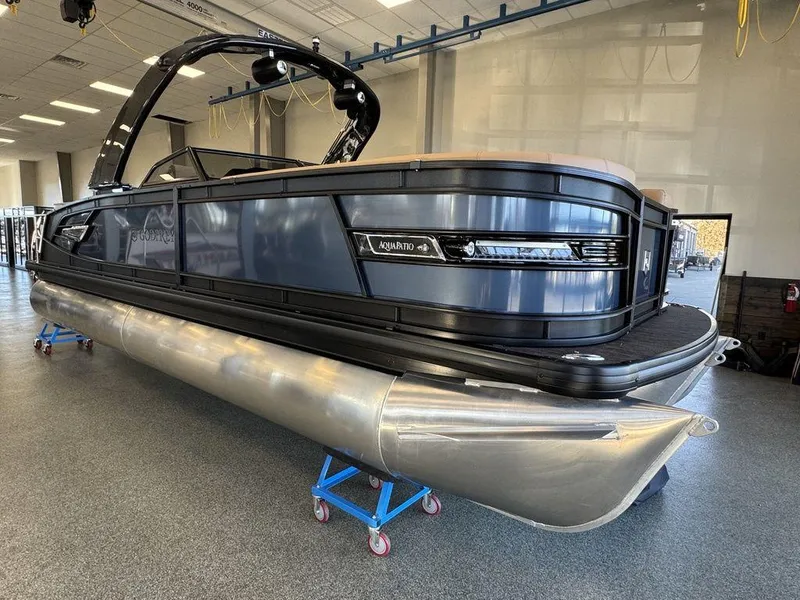 Slide: The Image of 2025 Godfrey AquaPatio 255 DFLW pontoon boat in showroom, sleek black design. - 9
