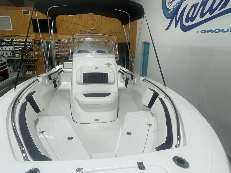 Slide: The Image of 2025 Tidewater 198CC boat interior with seating and console, displayed indoors. - 10