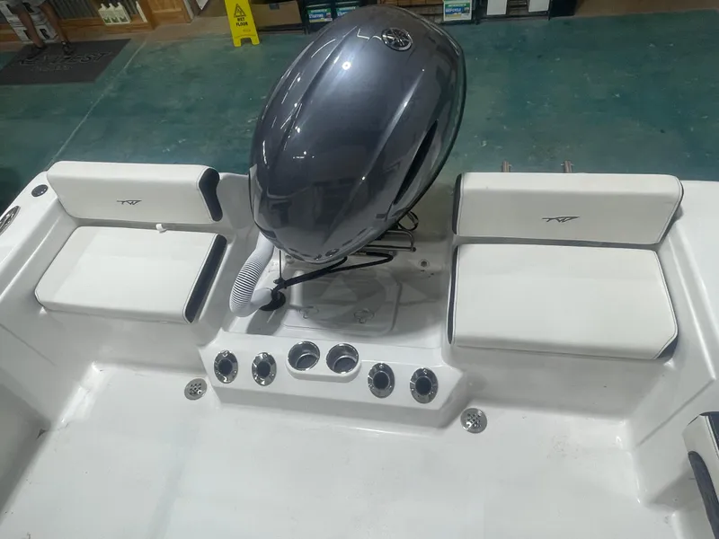 Slide: The Image of 2025 Tidewater 198CC boat interior with seating and engine, displayed indoors. - 17