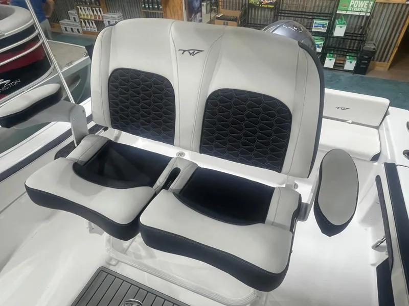 Slide: The Image of 2025 Tidewater 198CC boat seats with black and white upholstery in showroom. - 21