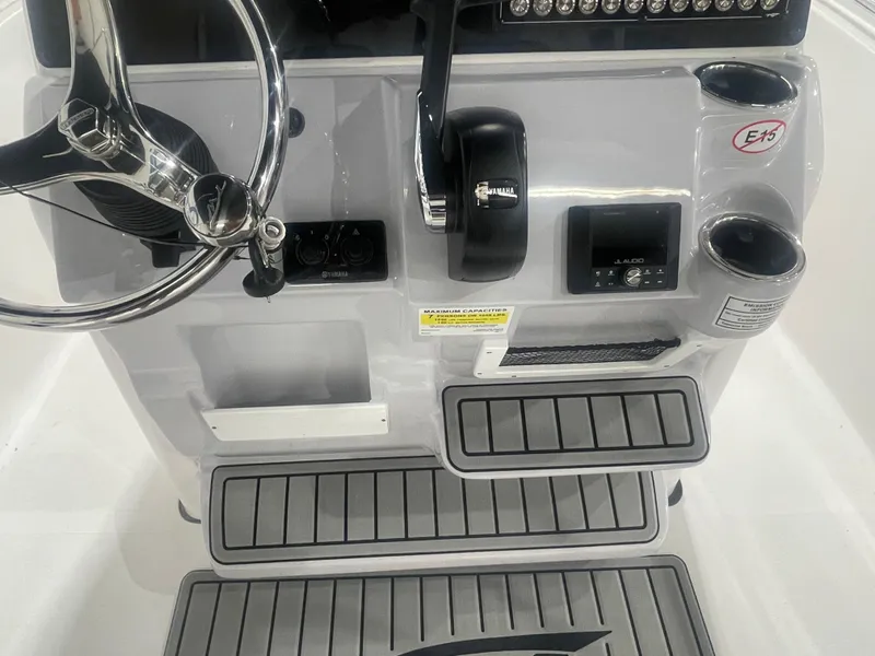Slide: The Image of 2025 Tidewater 198CC boat console with steering wheel, controls, and cup holders. - 24