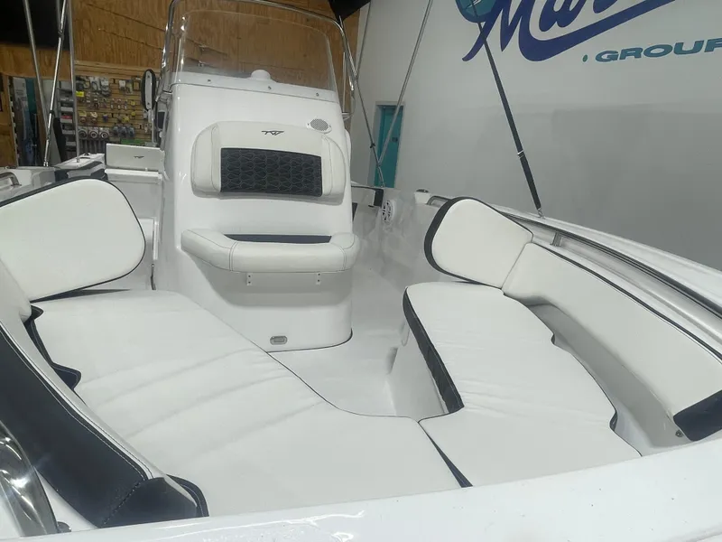 Slide: The Image of 2025 Tidewater 198CC boat interior with white seating and console in showroom. - 39