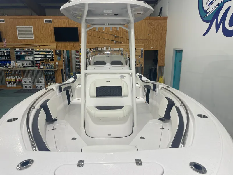 Slide: The Image of 2025 Tidewater 210LXF boat interior with seating and storage, displayed in a showroom. - 11