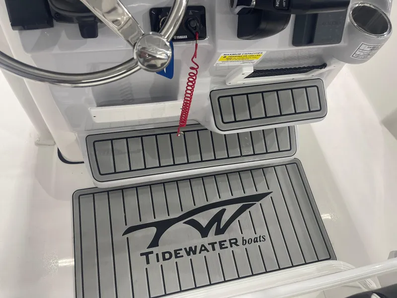 Slide: The Image of 2025 Tidewater 210LXF boat console with steering wheel and branded flooring. - 18
