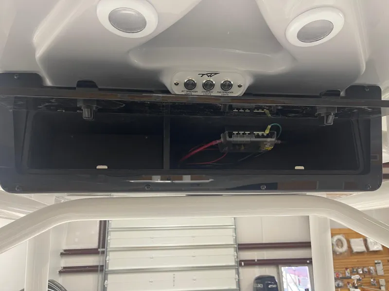 Slide: The Image of Tidewater 210LXF 2025 boat console with open storage compartment and control panel. - 22