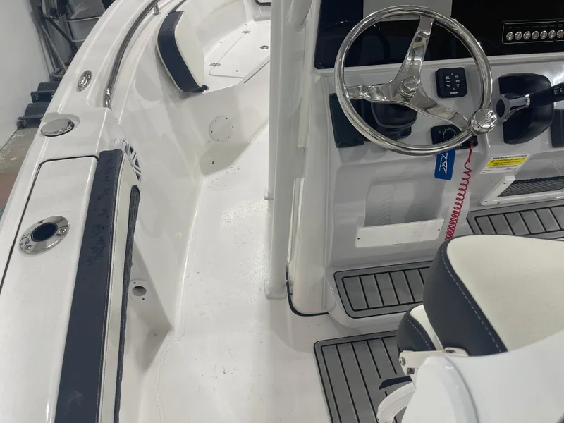 Slide: The Image of 2025 Tidewater 210LXF boat interior with steering wheel and seating. - 29