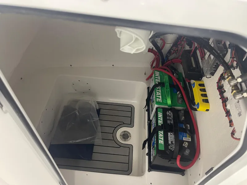 Slide: The Image of 2025 Tidewater 210LXF boat battery compartment with wiring and Interstate batteries. - 32