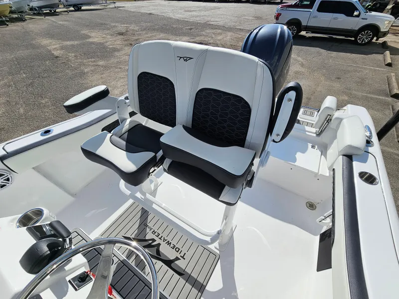 Slide: The Image of 2025 Tidewater 220LXF boat interior with dual seating and steering wheel. - 11