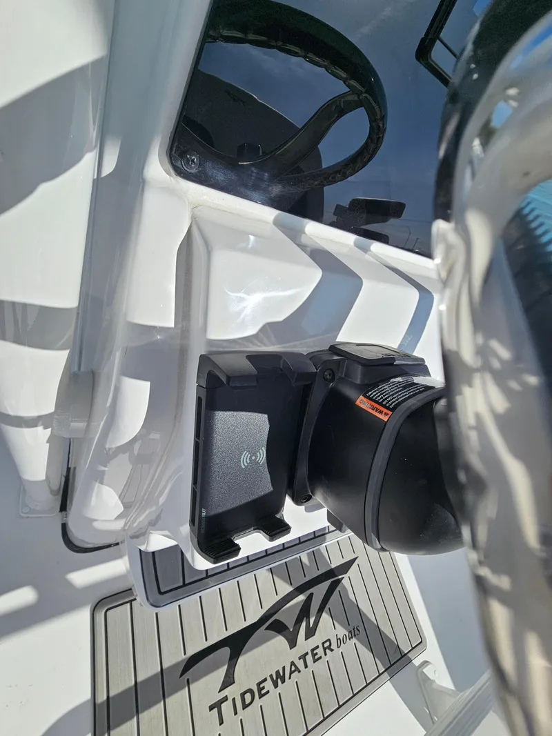 Slide: The Image of 2025 Tidewater 220LXF boat interior with steering wheel and branded mat. - 13