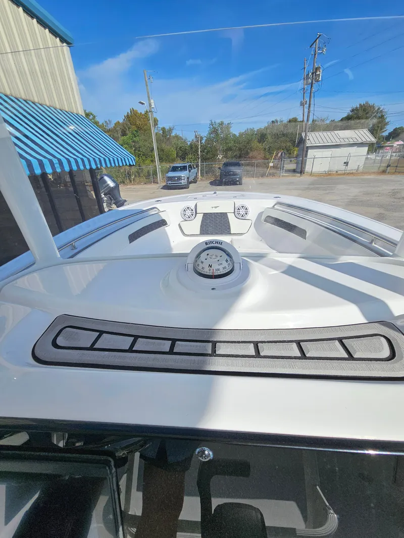 Slide: The Image of 2025 Tidewater 220LXF boat dashboard with compass, parked outdoors. - 17