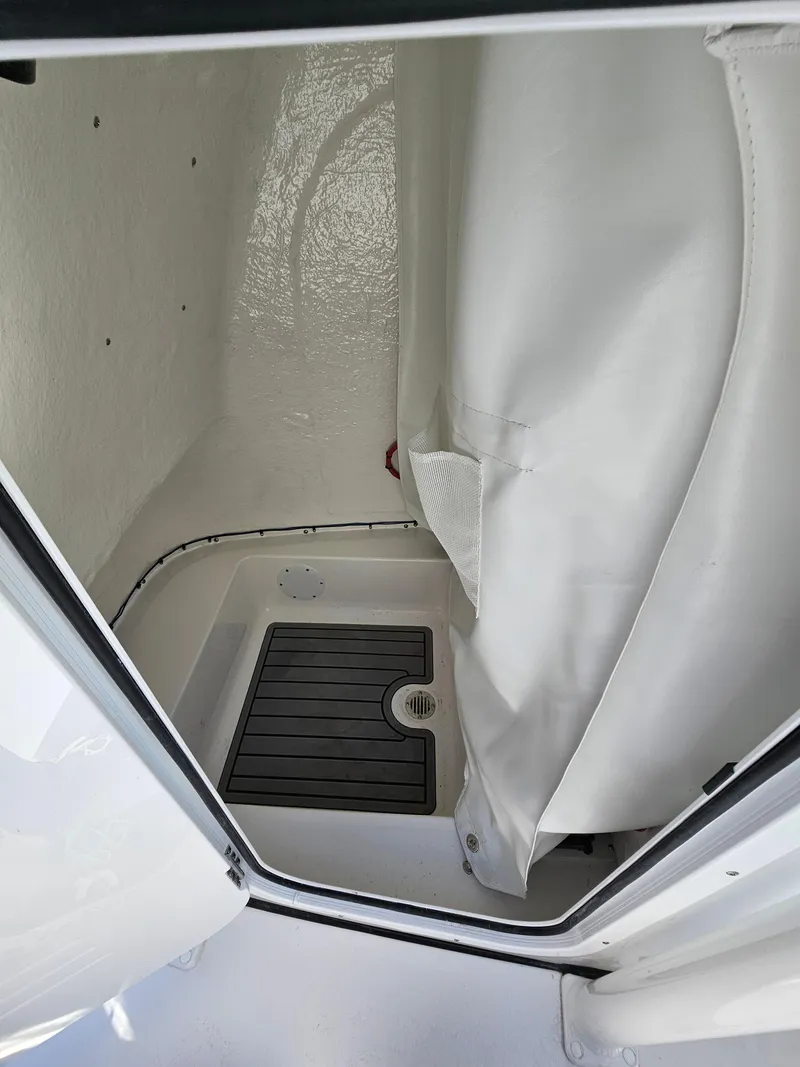 Slide: The Image of 2025 Tidewater 220LXF boat interior with shower area and curtain. - 25