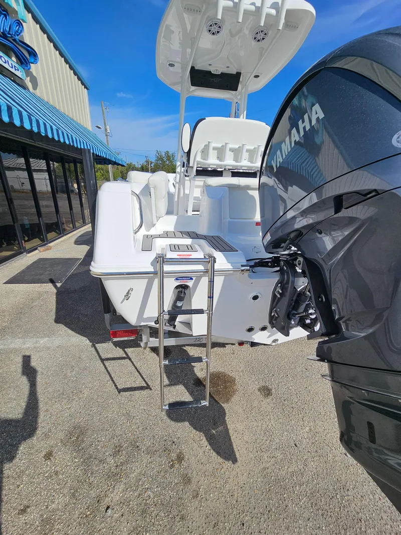 Slide: The Image of 2025 Tidewater 220LXF boat with Yamaha engine, rear view, docked outside. - 8