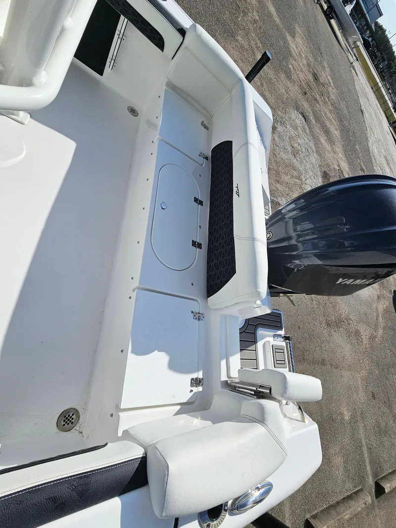 Slide: The Image of 2025 Tidewater 220LXF boat interior with Yamaha engine, white seating, and storage compartments. - 9