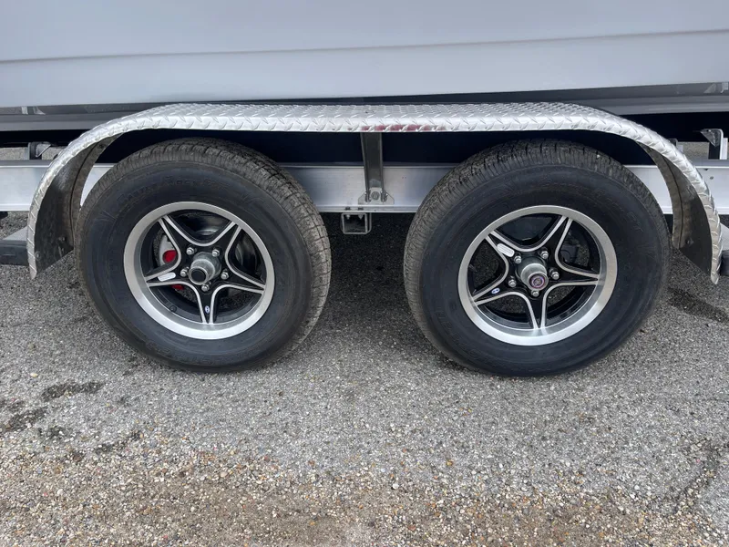 Slide: The Image of Trailer wheels of a 2025 Tidewater 232cc boat on gravel surface. - 12