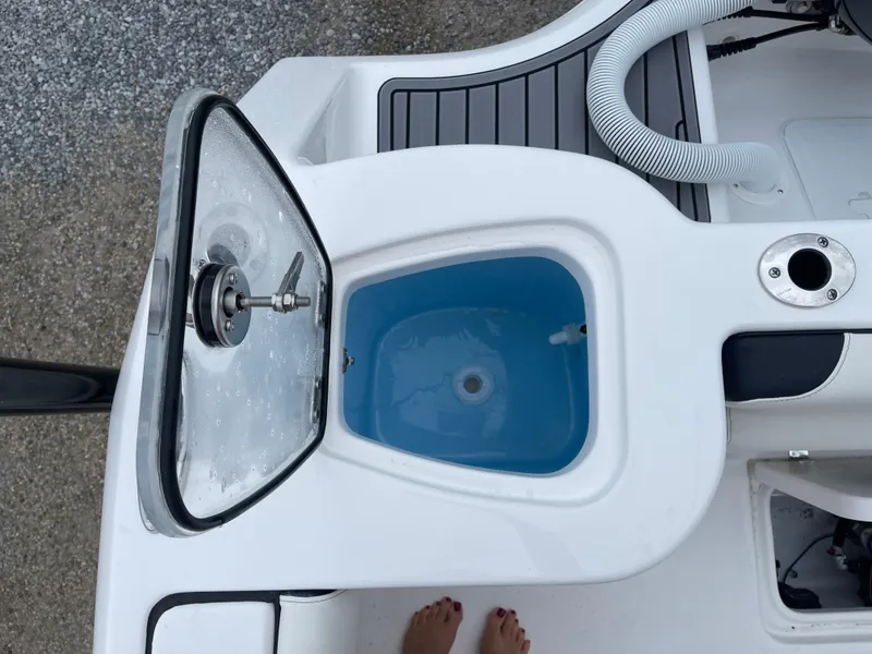 Slide: The Image of 2025 Tidewater 232cc boat livewell with open lid and visible plumbing. - 20