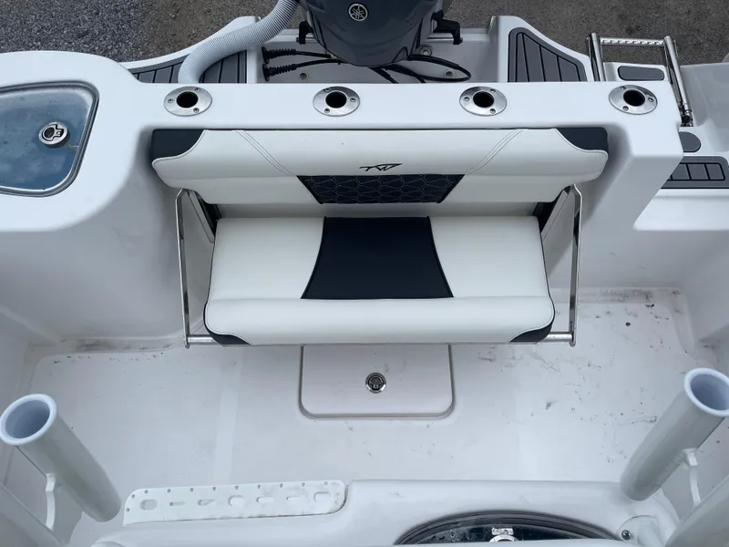 Slide: The Image of 2025 Tidewater 232cc boat seating area with rod holders and storage. - 21
