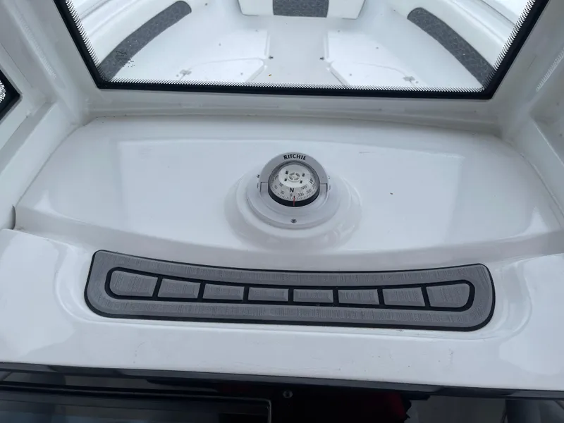 Slide: The Image of 2025 Tidewater 232cc boat dashboard with compass and control panel. - 25
