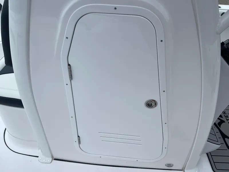 Slide: The Image of 2025 Tidewater 232cc boat storage compartment with white door and secure lock. - 28