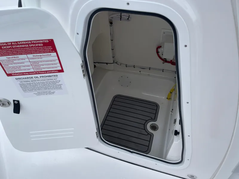 Slide: The Image of Open storage compartment on 2025 Tidewater 232cc boat with safety instructions. - 33
