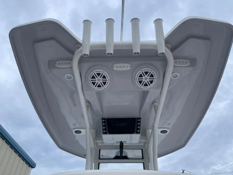 Slide: The Image of 2025 Tidewater 232cc boat T-top with speakers and rod holders against cloudy sky. - 43