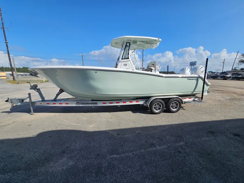 Slide: The Image of 2024 Tidewater 272cc boat on trailer under clear blue sky. - 1