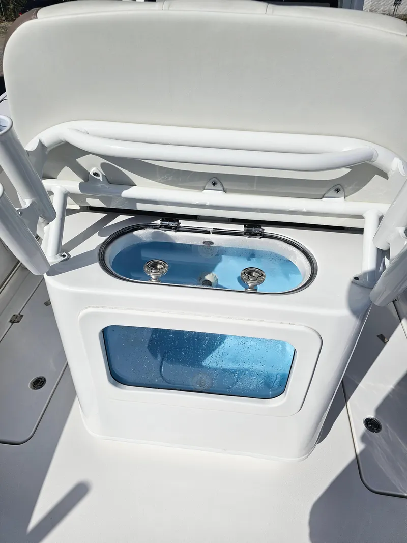 Slide: The Image of 2024 Tidewater 272cc boat livewell with white seating and blue interior. - 12
