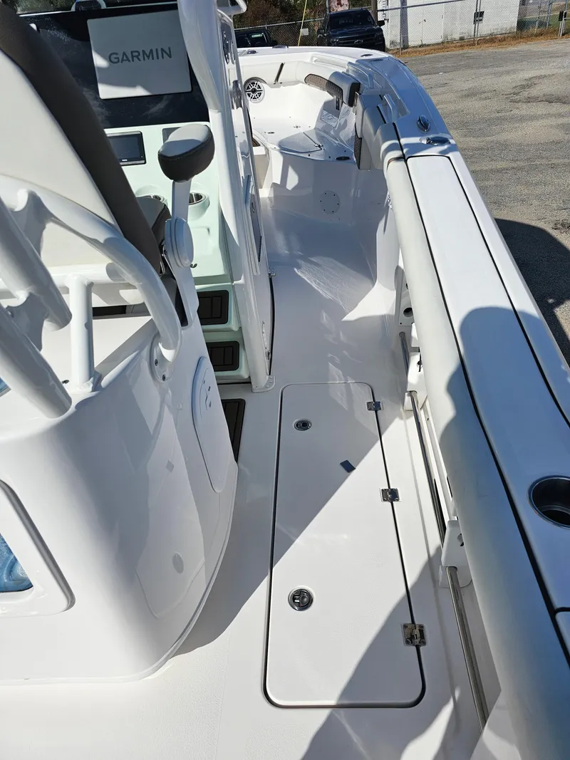 Slide: The Image of 2024 Tidewater 272cc boat interior with Garmin equipment, white deck, and seating area. - 13