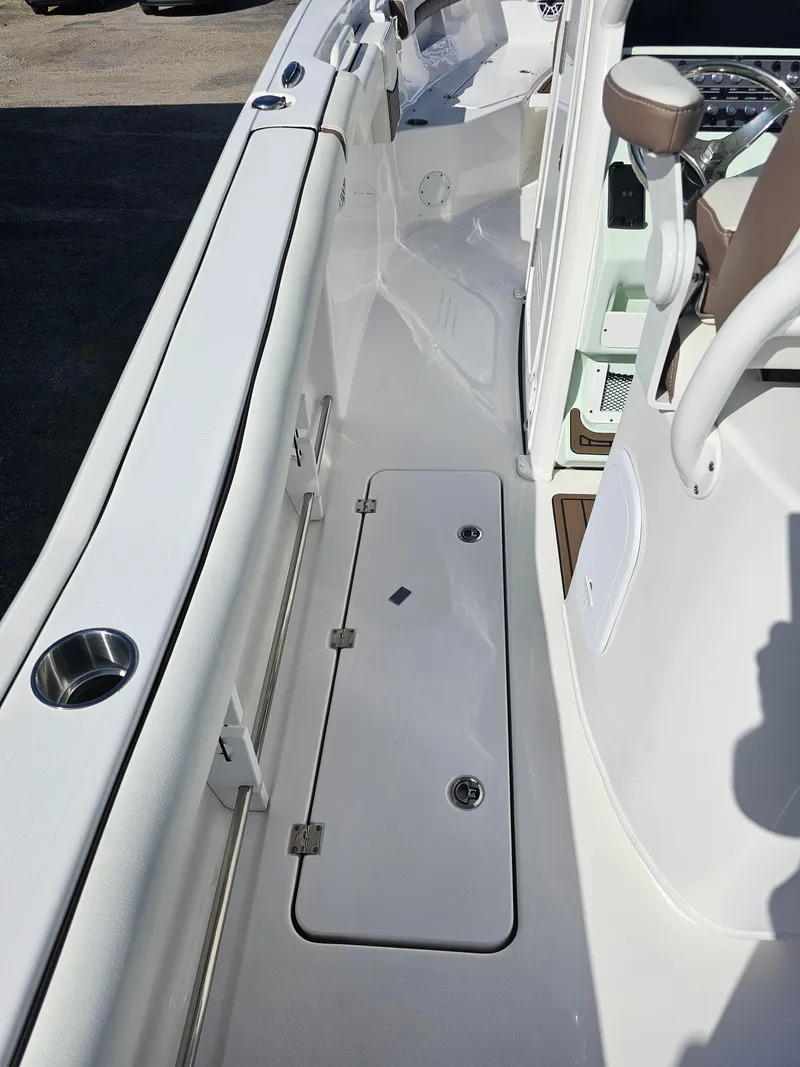 Slide: The Image of 2024 Tidewater 272cc boat interior, featuring sleek white deck and seating area. - 14
