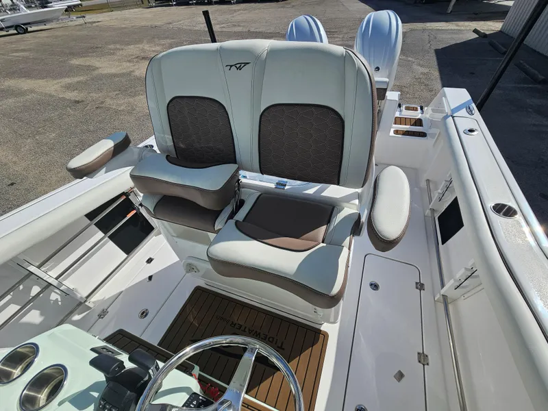 Slide: The Image of 2024 Tidewater 272cc boat interior with dual cushioned seats and steering console. - 15