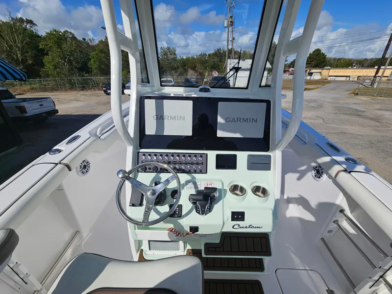 Slide: The Image of 2024 Tidewater 272cc boat dashboard with Garmin displays and steering wheel. - 16