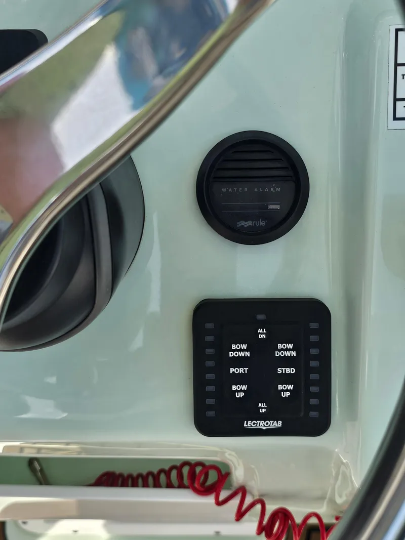 Slide: The Image of 2024 Tidewater 272cc boat control panel with water alarm and Lectrotab trim tab switches. - 19