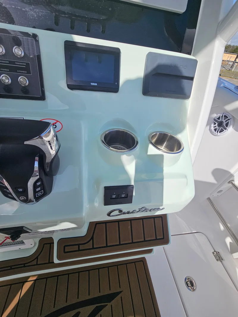 Slide: The Image of 2024 Tidewater 272cc boat console with controls, cup holders, and display screen. - 20