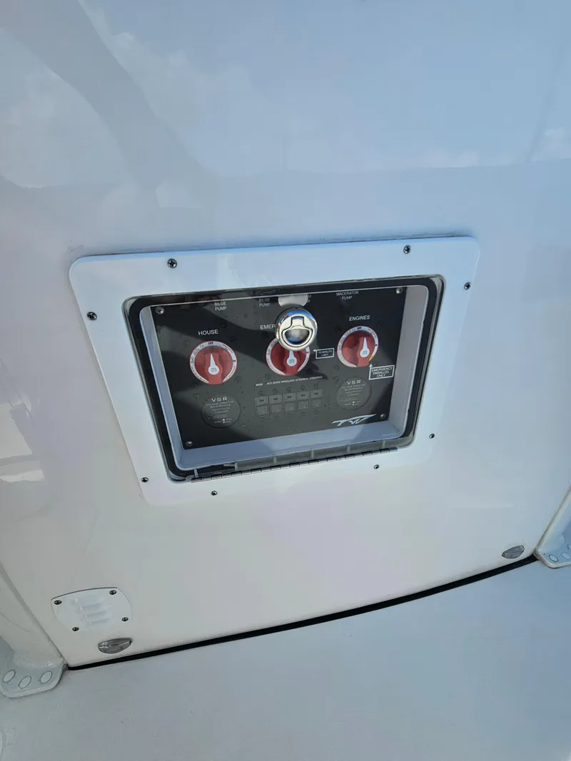 Slide: The Image of 2024 Tidewater 272cc boat control panel with red switches and key slot. - 23