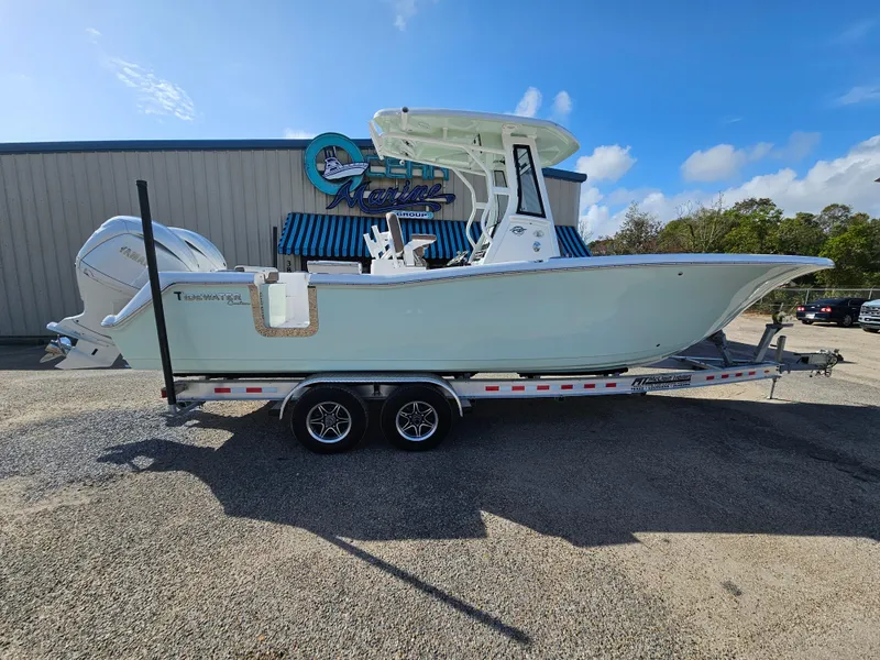 Slide: The Image of 2024 Tidewater 272cc boat on trailer outside marine shop, clear sky background. - 3