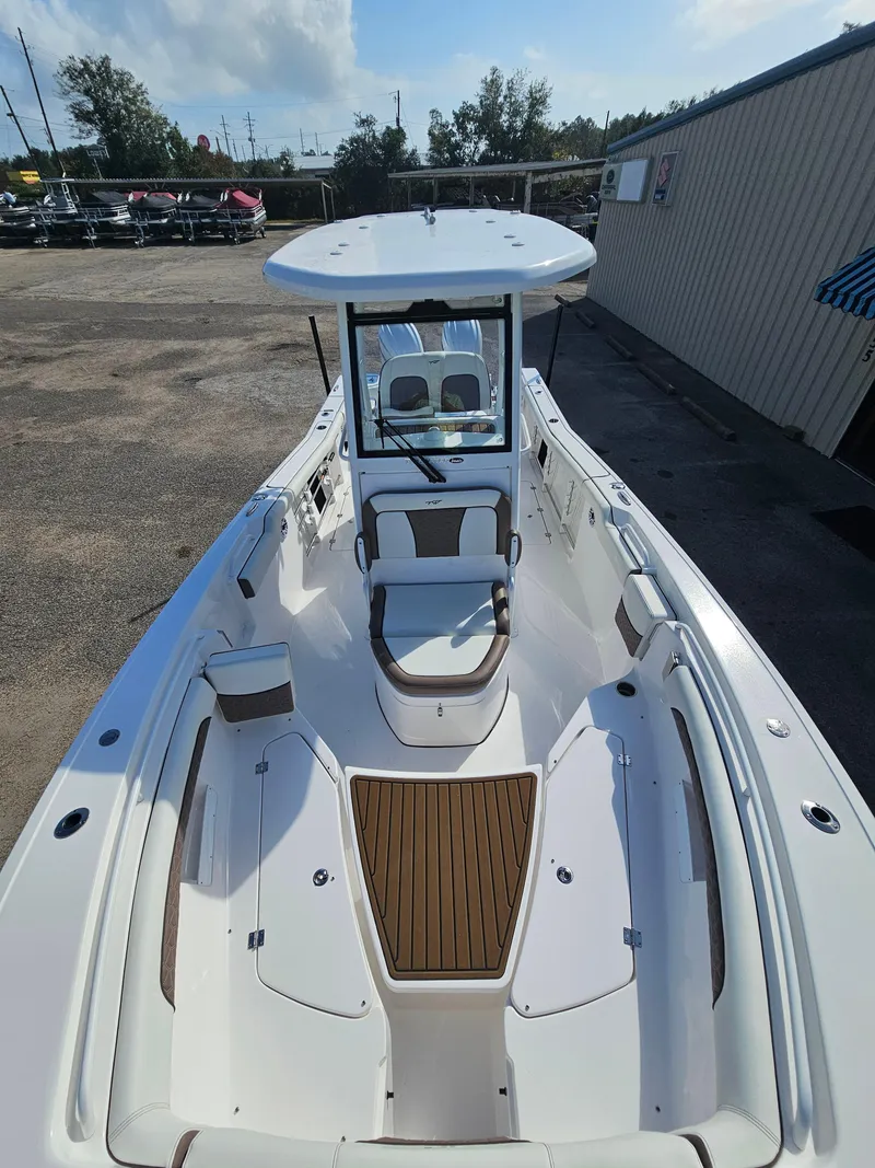 Slide: The Image of 2024 Tidewater 272cc boat with spacious deck and seating, parked outdoors. - 32