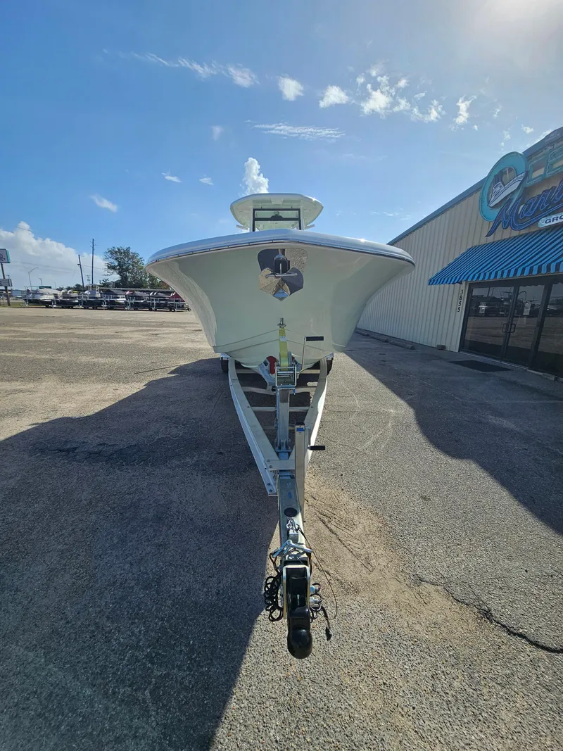 Slide: The Image of 2024 Tidewater 272cc boat on trailer, parked outside a building under a clear blue sky. - 5