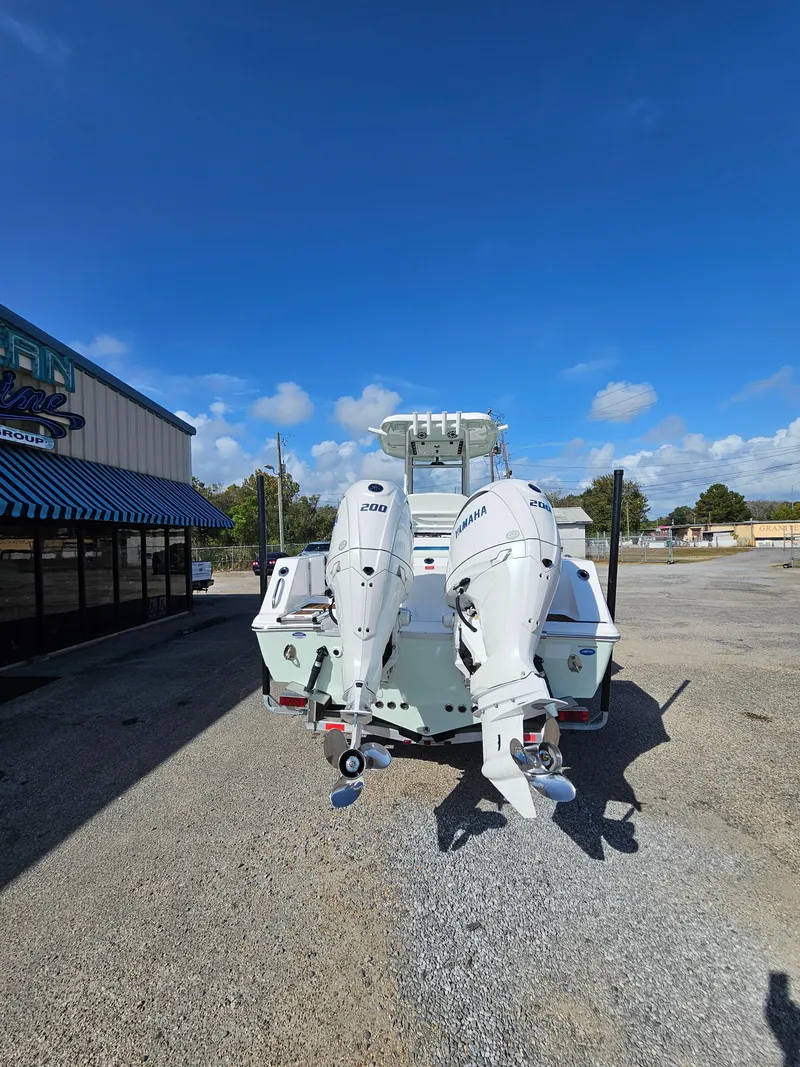 Slide: The Image of 2024 Tidewater 272cc boat with dual Yamaha outboard engines, parked outdoors. - 6