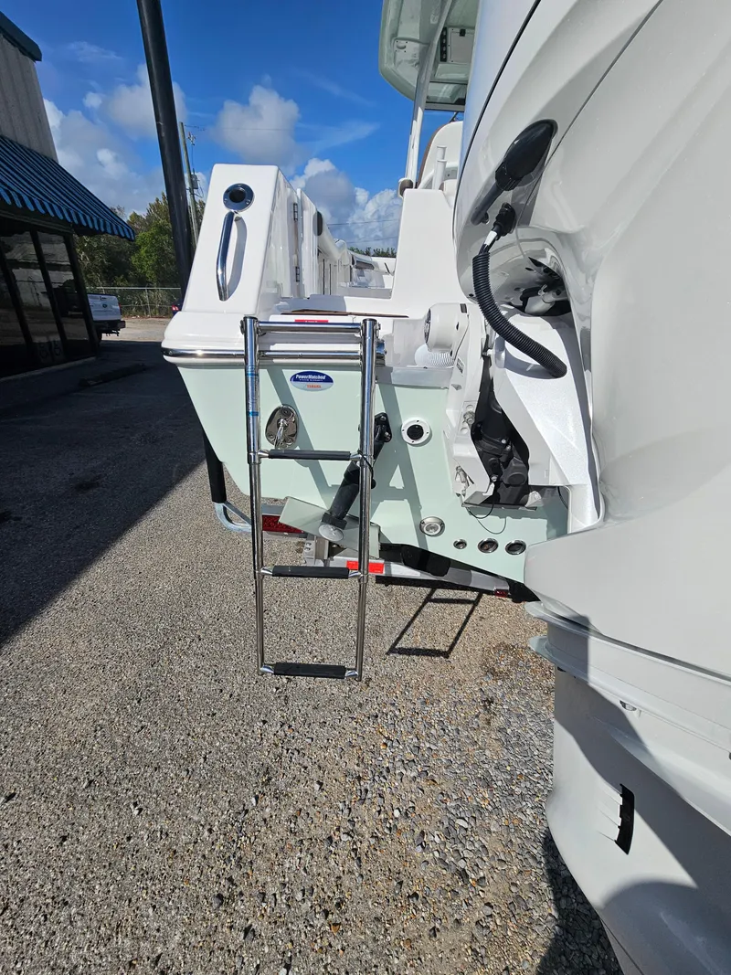 Slide: The Image of 2024 Tidewater 272cc boat with ladder, parked outdoors on a sunny day. - 7
