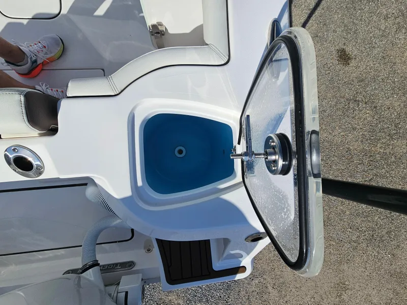 Slide: The Image of 2024 Tidewater 272cc boat interior with open storage compartment and seating. - 9