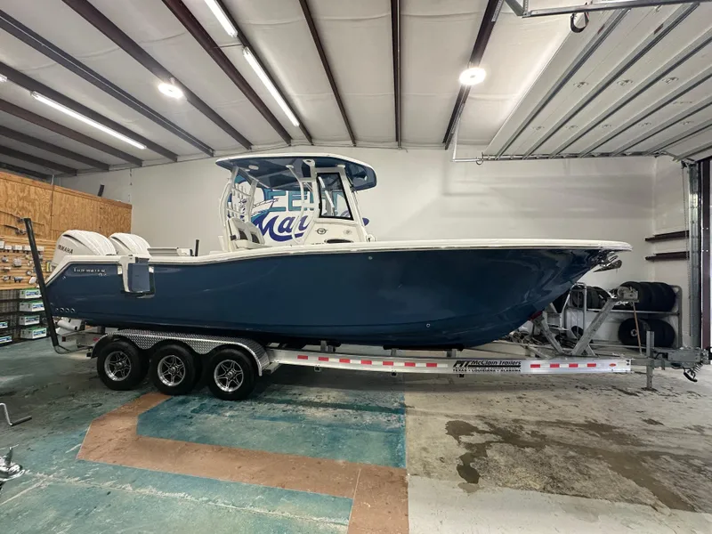 Slide: The Image of 2024 Tidewater 292CC boat on trailer in a garage setting. - 15